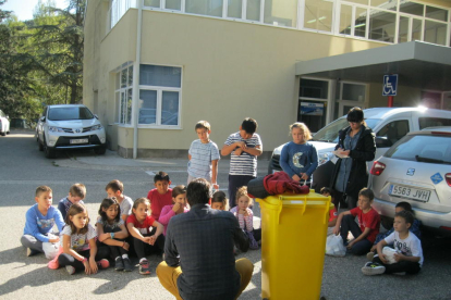 Tècnics del consell explicant als nens com han de reciclar.