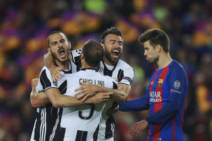 Piqué, cabizbajo, mientras varios jugadores de la Juventus celebran la clasificación.