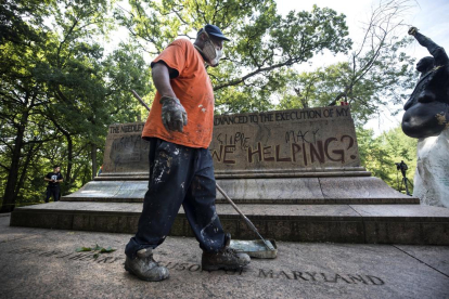 Un hombre limpia en un monumento confederado desmantelado.