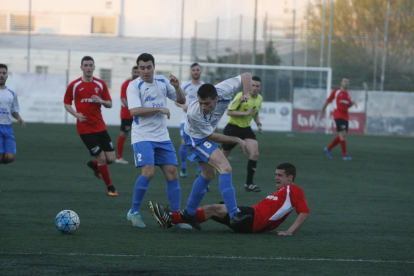 Un jugador del Castellserà se lanza a por el balón ante la presencia de varios jugadores del Mollerussa.