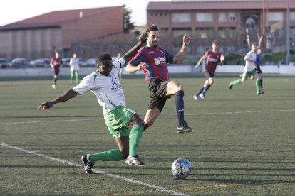 Un jugador del conjunto local y otro del Tàrrega pugnan por el balón en una de las jugadas que tuvo lugar durante el partido disputado ayer en el Municipal de Balàfia.