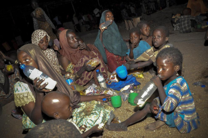 Una família nigeriana menja la seva ració d'aliments en un campament de desplaçats interns a Maiduguri