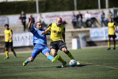 Un jugador del Balaguer refusa una pilota davant de la proximitat de dos jugadors rivals.