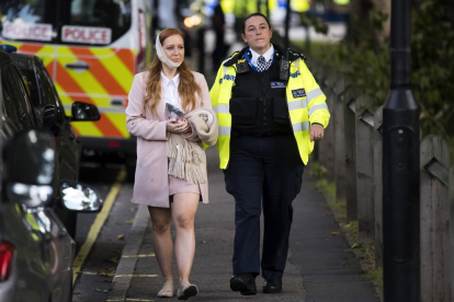 Una agent de policia escorta una ferida en l’atac al metro de Londres ahir.