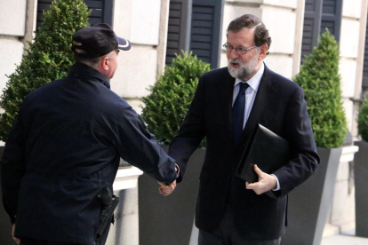 Mariano Rajoy, saludat per un policia ahir quan arribava al Congrés dels Diputats.
