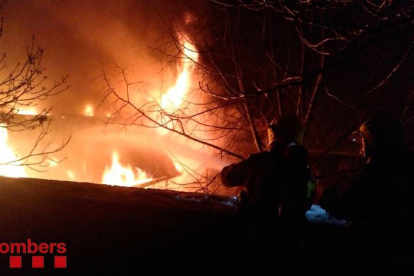 Bomberos trabajando la noche del lunes en el incendio de la casa de Éller, en Bellver de Cerdanya.