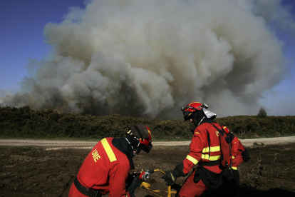Efectivos de Bomberos durante las labores de extinción del incendio en el municipio coruñés de Narón.