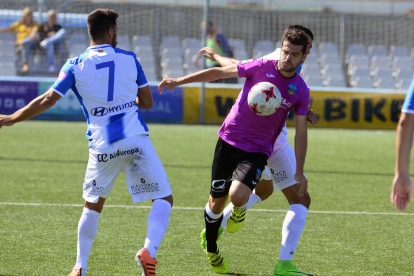 Andriu salta a buscar una pilota davant de la presència d’un jugador de l’At. Balears, en una acció del partit que el Lleida va jugar ahir a Son Malferit.