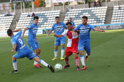 Varios jugadores del Lleida rodean a un futbolista del Sabadell, en una acción del partido de ayer en el Camp d’Esports.