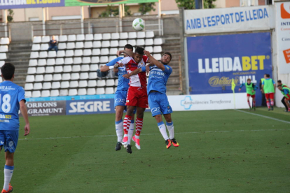 Jordan Gaspar lluita per una pilota entre dos jugadors del Lleida en una acció del partit d’ahir.