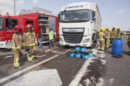 Los bomberos retiraron con cubos el combustible del camión tras el accidente en Ribera d’Ondara. 