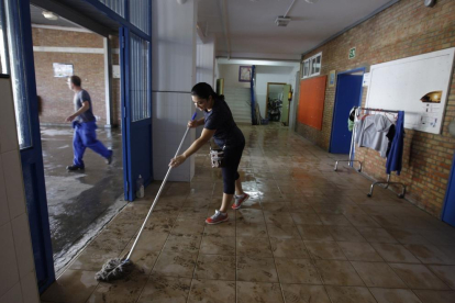 Una mujer limpia el barro en unas viviendas de Jerez de la Frontera. 