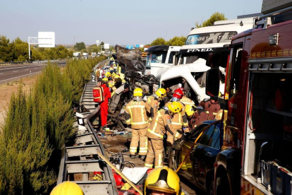 Efectius d'emergències auxiliant les persones atrapades als vehicles implicats en una col·lisió a l'A-2 a Lleida.