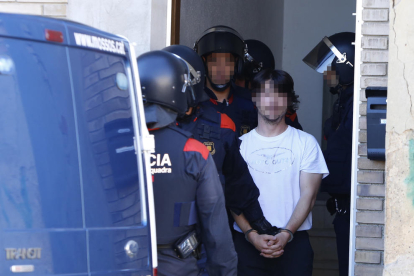 Uno de los detenidos, ayer a la salida de la vivienda de Torre-serona que registraron los Mossos. 