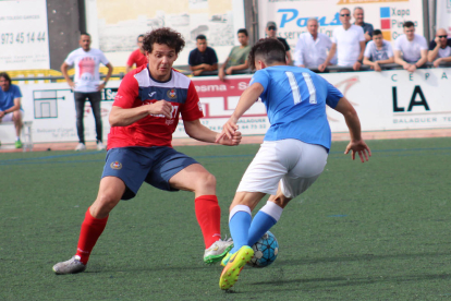 El jugador del Balaguer Carlos intenta impedir l’avanç d’un futbolista del Lleida Esportiu B.