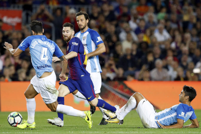 El azulgrana Sergio Busquets se lanza al césped para arrebatar el balón al argentino Emanuel Cecchini.