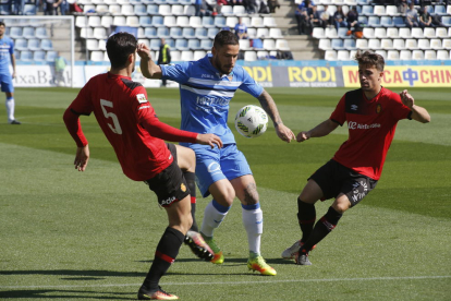 El centrocampista del Lleida, Miki Muñoz, disputa el balón con dos jugadores del Mallorca B.