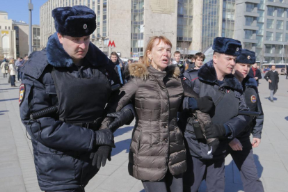 Policías rusos arrestan a una persona durante la marcha contra la corrupción.