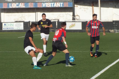 El local Joni defensa el control de la pilota davant de dos defensors del Térmens.