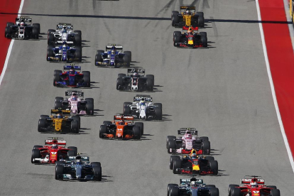 Lewis Hamilton y Sebastian Vettel pugnan por la primera plaza en el momento de la salida del Gran Premio de Estados Unidos.