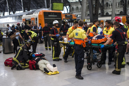 Los equipos de emergencias asistiendo a los heridos por el choque del tren ayer en la Estación de Francia en Barcelona.