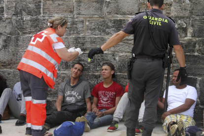 La Cruz Roja y la Guardia Civil, ayudando a los inmigrantes rescatados ayer.