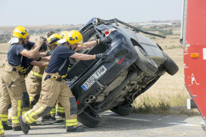 Bomberos y efectivos del SEM, ayer, trabajando en el lugar del accidente, la carretera L-310 en Concabella, que quedó cortada una hora.