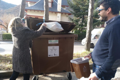 Una veïna diposita escombraries orgàniques al contenidor.