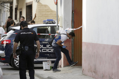 Un agent de la policia científica entra a l’habitatge on va tenir lloc l’assassinat ahir d’una dona a Sevilla.