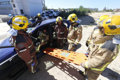 Bombers professionals mostren als aspirants un exercici d’excarceració en un vehicle al parc de bombers de Lleida.