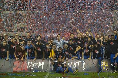 Los jugadores del Barça B celebran el ascenso a Segunda A sobre el césped del Mini.