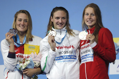 Mireia Belmonte mostra somrient la medalla amb l’hongaresa Hosszú i la canadenca Pickrem.