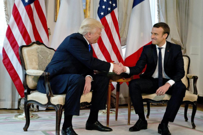 Trump estrecha la mano del presidente francés Emmanuel Macron.