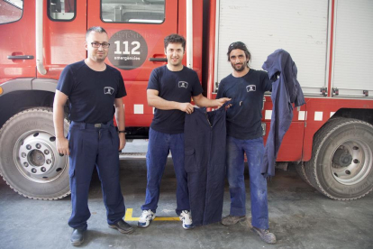 Los bomberos muestran pantalones que tienen rotos y los que se han tenido que comprar. 