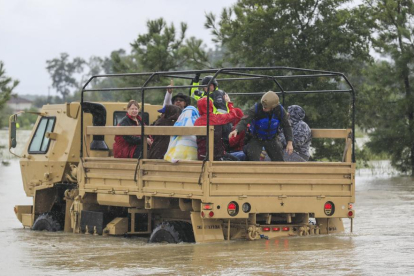 Camiones de la Guardia Nacional de Texas llevan a personas afectadas por las inundaciones en Houston.