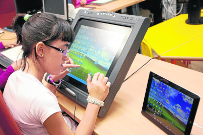 Una alumna amb discapacitat visual utilitzant una pantalla adaptada a classe.