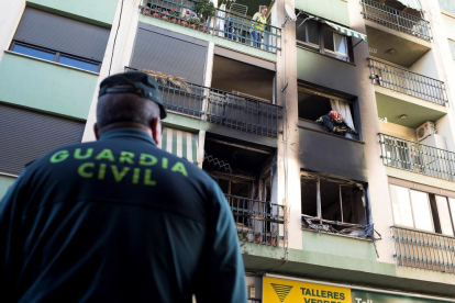 Un agent de la Guàrdia Civil observa l’habitatge incendiat ubicat al municipi de Burriana.