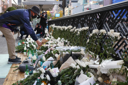 Un ciutadà diposita una flor en un altar en honor a les víctimes.