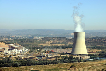 La central nuclear de Ascó, en la Ribera d'Ebre, con la chimenea humeante a la derecha y los dos reactores a la izquierda