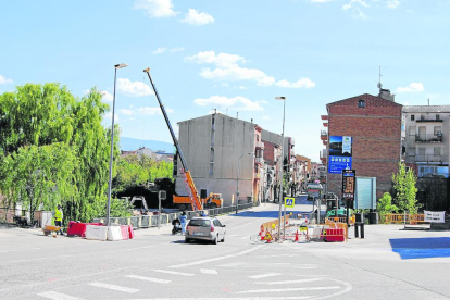 Les obres de la nova rotonda de Tremp i a la dreta, una pancarta contra el projecte.