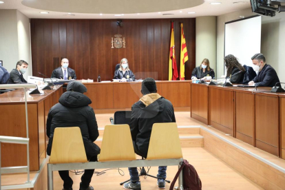La Sala de l'Audiència de Lleida durant el judici a un acusat (esquerra) d'agredir sexualment la filla, amb el traductor (dreta).