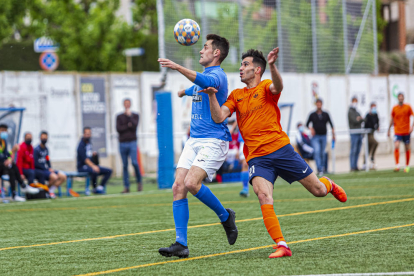 Dos jugadors de l’Alcarràs tallen l’avanç d’un rival de l’Atlètic Lleida.