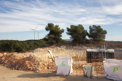 Obras de un molino del parque eólico de Solans, con aerogeneradores de La Granadella al fondo.