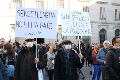 Dos manifestants amb pancartes a la plaça Sant Jaume.