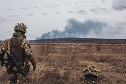 Un soldat de l'exercito ucraïnès observa el fum dels bombardejos a Irpin.