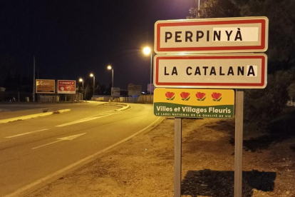 Un cartell dona la benvinguda a la capital del Rosselló en català.