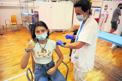 Imatge d’arxiu d’una infermera administrant una vacuna de la Covid-19 a una jove.