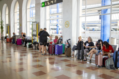 Varios viajeros esperando ayer en la estación Lleida-Pirineus tras la suspensión de trenes.