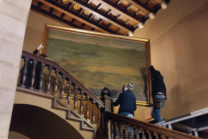 Les tasques de retirada del quadre de l'escala del Palau de la Paeria.