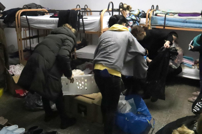Varias mujeres refugiadas de Ucrania organizando ropa que les han dado algunos vecinos de la Garrotxa y el Pla de l'Estany mientras se adaptan a la casa de colonias donde vivirán los próximos meses